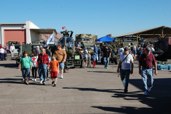 crowd enjoys the vehicles, venders, and real vehicles in the background.