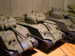 Individual masks were cut from 3M blue tape (long mask) for the "stars" that will be left in olive green. Although I want all of the tanks to look like they belong to the same tank battalion I also want each tank to keep it's unique individuality. So one tank has stars on the turret and hull, one has stars on the turret and transmission cover and the third has stars only on the hull sides. Then I decided to do the M-36 in white stars (the white wash will be "washed away" to show the green undercoat around the white stars). Each tank will also get unique stowage and equipment as well (as you can also see one has had applique armor added, and mine has the brackets and wooden shelf added to the front end)