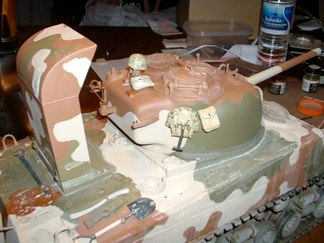 Testor’s MM OD sprayed onto kit and stacks in the appropriate camo scheme for the Iwo Jima vehicle.  I cleaned up a few goofs and am pleased with the result.  Now I begin to wash the vehicle with diluted acrylic paint.  A few infantry accessories are added to the turret for diversity and I begin the weathering process in earnest.  The washes are helping blend the colors and mute the overall scheme.