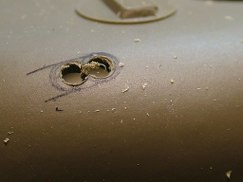 I marked the location using a circle template to draw and mark the center of two adjacent circles. Used a center punch to mark the center and then using a 3/64 drill bit I drilled out both holes. Using a ball end burr in a dremel I thinned the turret plastic directly behind the mortar launcher to give it a more scale appearance.Then I used a fine dremel burr bit and round files to clean up the hole and make it a more symmetrical shape